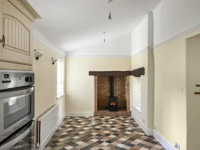 a living room with a fireplace and a checkered floor at The Farmhouse - Uk49068 in Liskeard