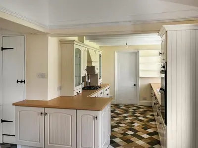 a kitchen with white cabinets and a checkered floor at The Farmhouse - Uk49068 in Liskeard