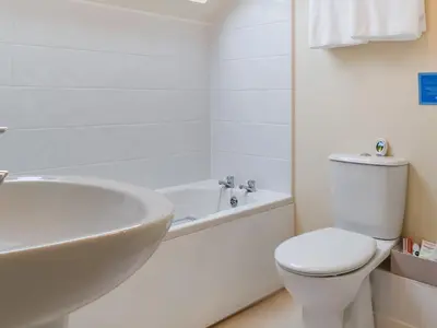 a white bathroom with a toilet and a tub and a sink at Cowshed - Uk49024 in Liskeard