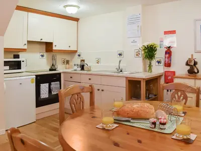 a kitchen with a table with a loaf of bread on it at Cowshed - Uk49024 in Liskeard