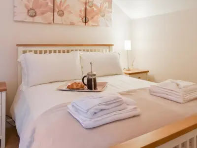 a white bed with a tray of food on it at Cowshed - Uk49024 in Liskeard