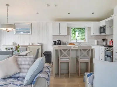 a kitchen and living room with a couch and a table at Edmonton Lodge - Uk50308 in Doublebois
