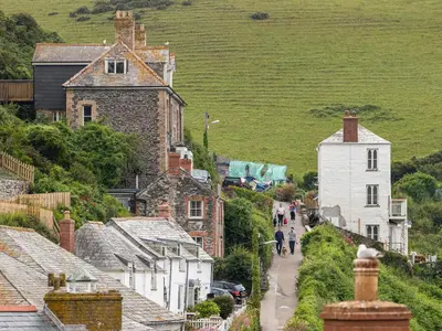 a group of people walking down a street in a village at Geranium Cottage in Port Isaac