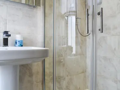a bathroom with a sink and a shower at Seagull Cottage in Looe