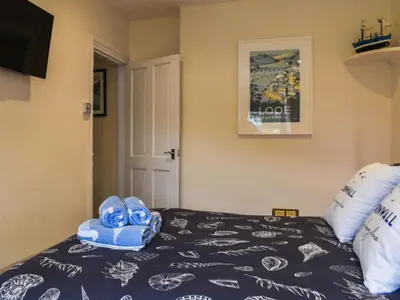 a bedroom with a bed with blue towels on it at Seagull Cottage in Looe