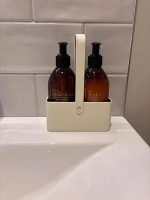 two bottles of soap sitting on a shelf in a bathroom at Porthtowan Guest Suite in Porthtowan