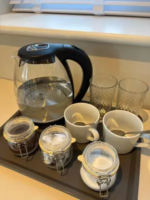a tea kettle and cups on a tray on a counter at Porthtowan Guest Suite in Porthtowan
