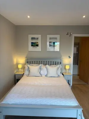 a bedroom with a large bed with two tables at Porthtowan Guest Suite in Porthtowan