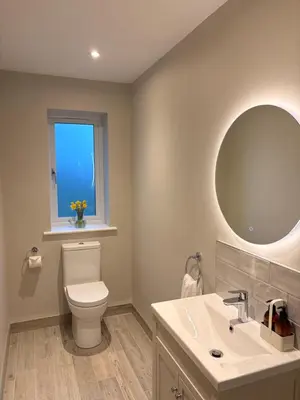a bathroom with a toilet and a sink and a mirror at Porthtowan Guest Suite in Porthtowan