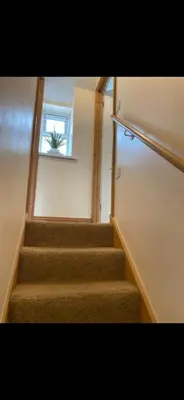 a staircase with a window and a plant on the window sill at Sunset Apartments Newquay in Newquay