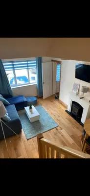a living room with a blue couch and a fireplace at Sunset Apartments Newquay in Newquay
