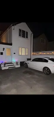 a white car parked in front of a house at Sunset Apartments Newquay in Newquay