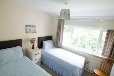 two beds in a bedroom with a window at Entire 2 bedroom house in a great Cornish location in Saint Columb Road Station