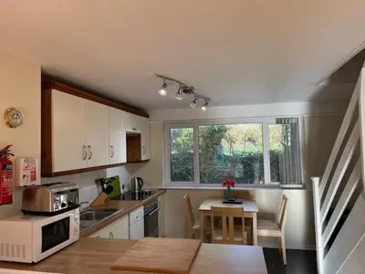 a kitchen with a table and a microwave oven at Entire 2 bedroom house in a great Cornish location in Saint Columb Road Station