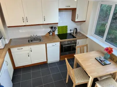 a small kitchen with a table and a table and chairs at Entire 2 bedroom house in a great Cornish location in Saint Columb Road Station