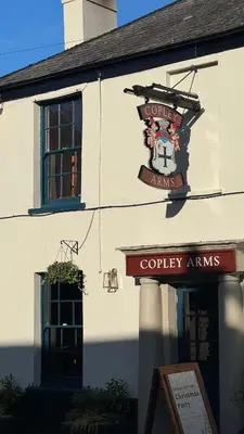 a building with a sign on the side of it at The Copley Arms in Downderry