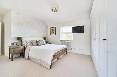 a white bedroom with a bed and a window at Idyllic Cornish House in St. Agnes