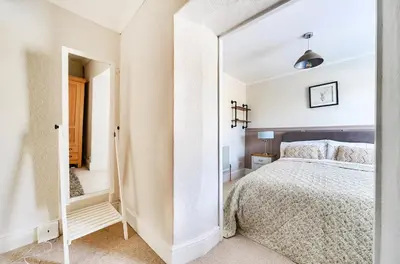 a bedroom with a large mirror next to a bed at Idyllic Cornish House in St. Agnes
