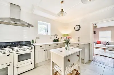 a kitchen with white cabinets and a stove at Idyllic Cornish House in St. Agnes