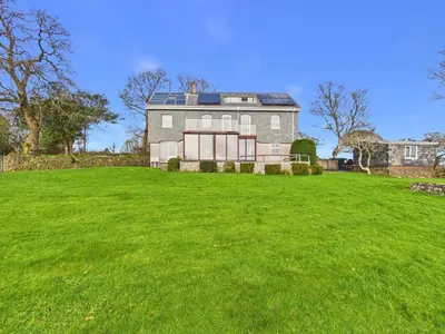 a large house with a large green yard at The Crows Nest – Sea View Retreat, Flushing Cornwall in Falmouth