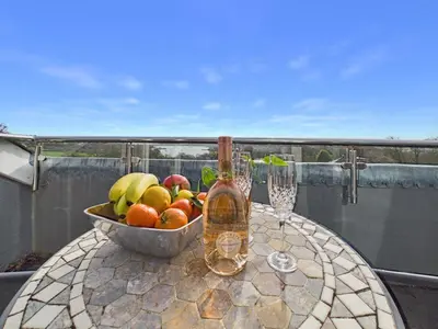 a bowl of fruit on a table on a balcony at The Crows Nest – Sea View Retreat, Flushing Cornwall in Falmouth