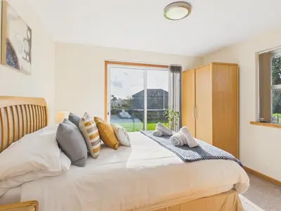 a bedroom with a large bed with a window at The Crows Nest – Sea View Retreat, Flushing Cornwall in Falmouth