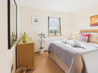 a bedroom with a bed and a mirror at The Crows Nest – Sea View Retreat, Flushing Cornwall in Falmouth