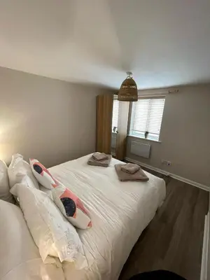 a bedroom with a large white bed with towels on it at Harbour Hideaway, Porthleven in Porthleven