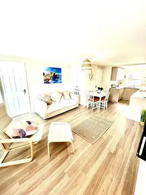 a living room with a couch and a table at Harbour Hideaway, Porthleven in Porthleven