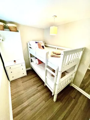 a bedroom with two bunk beds and a wooden floor at Harbour Hideaway, Porthleven in Porthleven