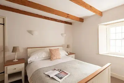 a bedroom with a bed with a magazine on it at Homelands in Port Isaac