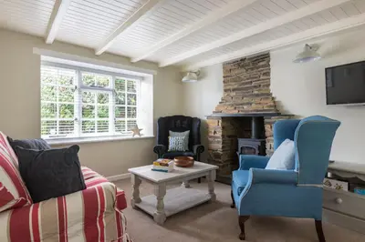 a living room with a couch and a fireplace at Poplar Cottage in Port Isaac