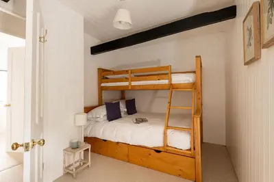 a bedroom with two bunk beds and a ladder at Portcor in Port Isaac