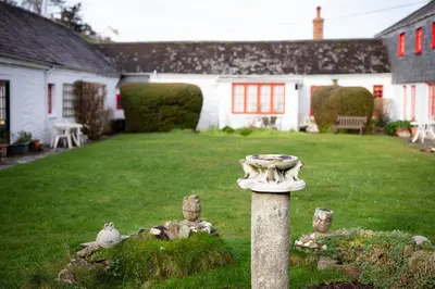 a stone birdbath in the yard of a house at Portcor in Port Isaac
