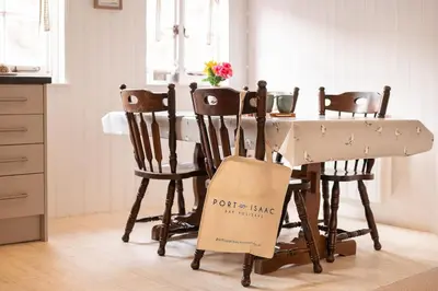 a table with chairs and a sign that says potkins king on it at Portcor in Port Isaac