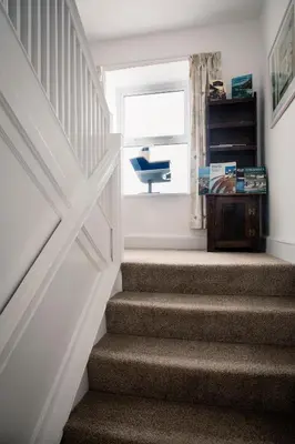 a stairway with a door and a window at Ensuite room only in beautiful former farmhouse garden and parking in St Ives