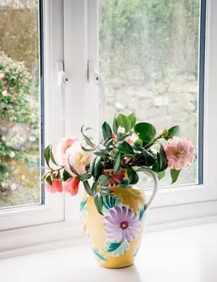 a vase filled with flowers sitting on a window sill at Ensuite room only in beautiful former farmhouse garden and parking in St Ives
