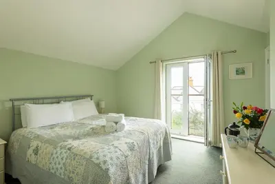 a bedroom with a bed and a window at White Horses in Port Isaac