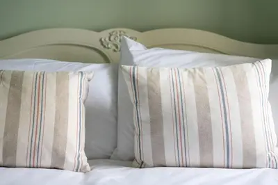 a bed with two pillows on top of it at White Horses in Port Isaac
