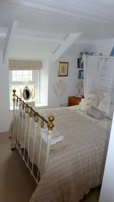 a bedroom with a bed with a white bedspread and a window at Trewetha Cottage Bed & Breakfast in Port Isaac