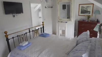 a bedroom with a bed with two blue towels on it at Trewetha Cottage Bed & Breakfast in Port Isaac