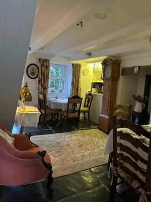 a living room with a table and a kitchen at Trewetha Cottage Bed & Breakfast in Port Isaac