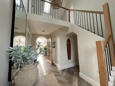 a hallway with a staircase and a vase with a plant at SeaNest and cabin, walk to beach in St. Agnes