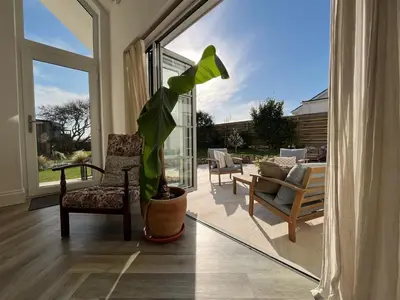 a living room with a potted plant and a large window at SeaNest and cabin, walk to beach in St. Agnes