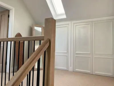 a room with a staircase with white walls and a skylight at SeaNest and cabin, walk to beach in St. Agnes