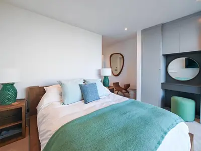 a bedroom with a bed with blue pillows and a mirror at 3 Bed in Constantine Bay oc-t34218 in St Merryn