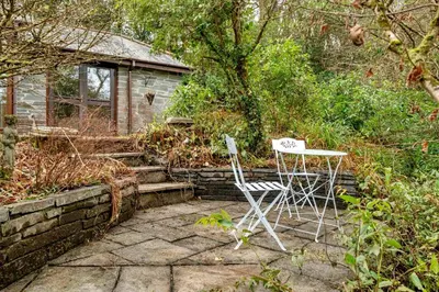 two chairs and a table in front of a house at 2 Bed in Tresarrett oc-b34255 in Blisland