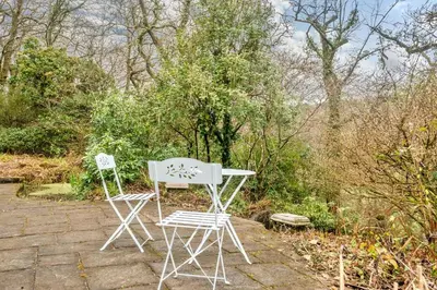 two white chairs and a table in a garden at 2 Bed in Tresarrett oc-b34255 in Blisland