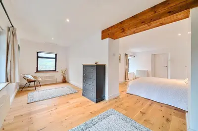 a bedroom with a large bed and a wooden floor at 4 Bed in Tresarrett oc-b34254 in Blisland