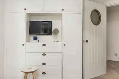 a white dresser with a tv and a mirror at Emerald - Stunning Views - Free Parking and WiFi - Coffee Machine in Carbis Bay